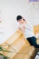 A woman sitting on top of a yellow couch.